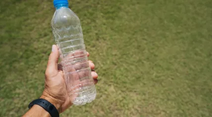Man holding an empty plastic bottle.