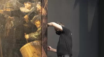 Workers at the Rijksmuseum attach a reproduction of a piece missing from Rembrandt's Night Watch. January 2021