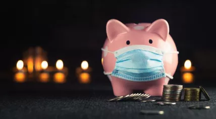 Piggy bank in a mask on a background of blurry lights.