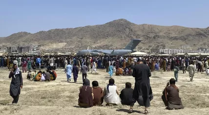Hundreds of people gather near a U.S. Air Force C-17 transport plane at a perimeter at the international airport in Kabul, Afghanistan, Monday, 16 August 2021