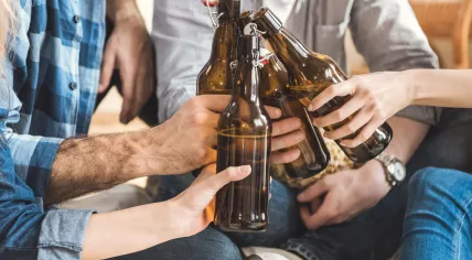 People clinking beer bottles