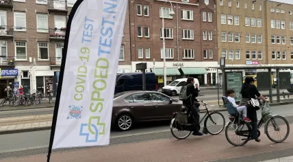 A banner waves outside a commercial coronavirus test center in Amsterdam. July 28, 2021