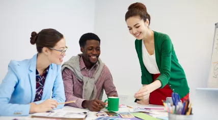 Stock image of desingers gathering around table