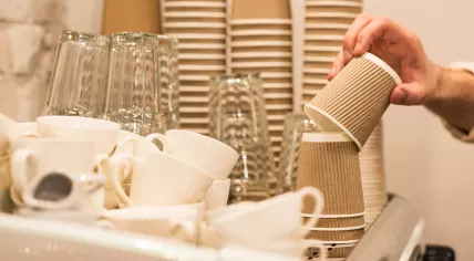 Cropped view of barista holding brown disposable cup