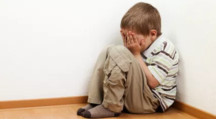 Child cowering in a corner