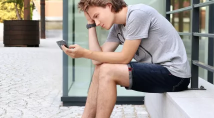 Teenager looking at a phone.