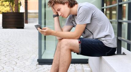 Stock image of teenager looking at phone