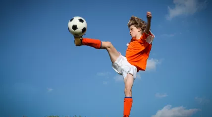 Stock image of kid plying football 