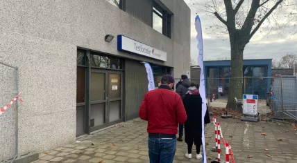 A line wraps out the door of a coronavirus test location in Amsterdam. 24 Nov. 2021