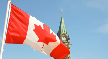 Canadian flag waving in front of the Parliament Building 