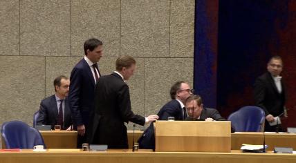 Medical Care Minister Bruno Bruins is helped to his feet by Social Affairs Minister Wouter Koolmees moments after Bruins collapsed in the Tweede Kamer. 18 March 2020