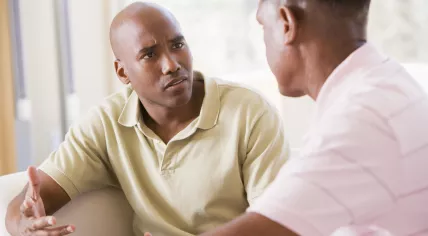Stock image of two men arguing in living room