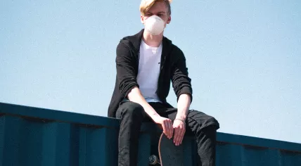 A young skateboarder wearing a face mask. April 2020