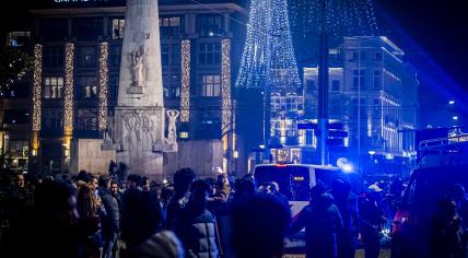 Riot police arrive at the National Monument on Dam Square to break up a New Year’s party in Amsterdam. 1 Jan. 2022