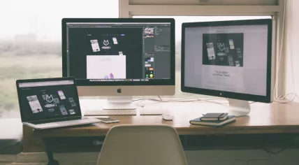 Desk with three computer screens