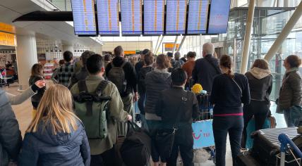 Travelers check flight statuses at Schiphol Airport on April 23, 2022.