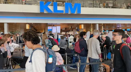 Travelers wait in line in a Schiphol Airport departure hall on April 23, 2022.