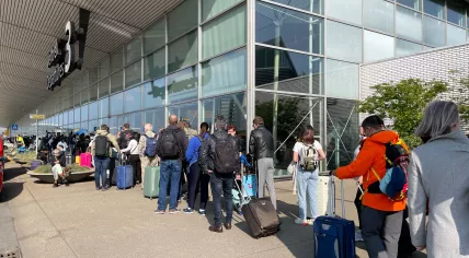 Passengers wait in line at Schiphol Airport between departure halls 2 and 3 on April 23, 2022. 
