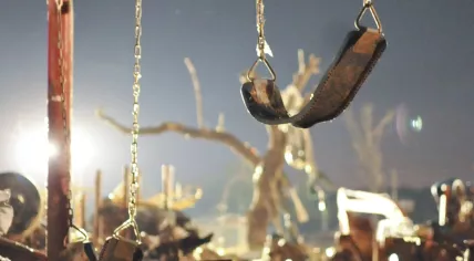 Swing set surrounded by debris