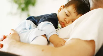 Baby sleeping on dad's chest