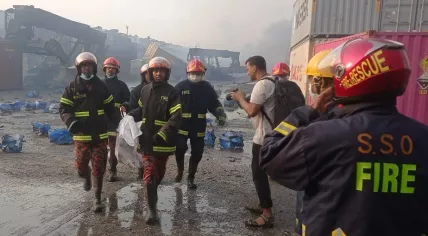 Firefighters carry a body away from a container depot fire in Chittagong, Bangladesh on June 5, 2022.