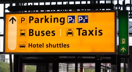 Sign pointing to bus, taxi, and shuttle stops at Schiphol airport