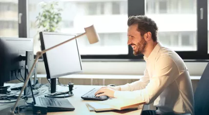 A worker sitting behind his desk using a computer