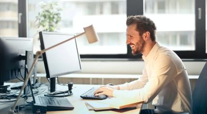 A worker sitting behind his desk using a computer