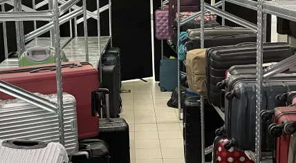 Suitcases stacked up behind screens in the baggage claim area at Schiphol Airport Arrivals Hall 2.  21 July 2022
