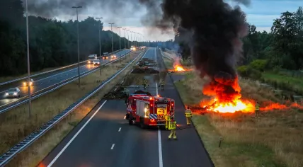 Firefighters fighting a fire set by farmers on the A50 near Apeldoorn, 27 July 2022