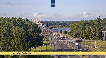 A view to the south on the A27 near Gorinchem as caravans, trucks, and many cars with trailers or rooftop boxes drive by on 16 July 2022