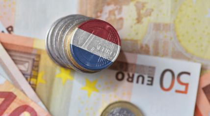 Dutch flag on a euro coin with banknotes in the background