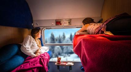 A TUI night train with a snowy landscape outside the window