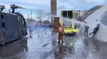 A police water cannon strikes a woman during a protest against coronavirus measures in Eindhoven. 24 January 2021