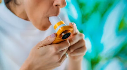 Woman using Spirometer, measuring lung capacity