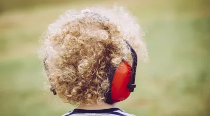 Child wearing noise-blocking headphones
