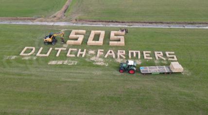 Hay bales arranged along the La Vuelta 2022 course spell out "SOS Dutch farmers" on Aug. 20, 2022.