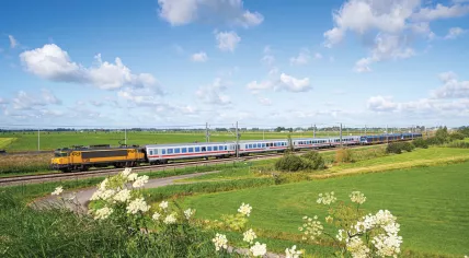 The Intercity Berlin crossing the countryside with the NS-branded locomotive and Deutsche Bahn carriages