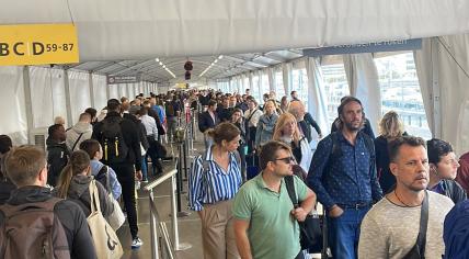 Travelers wait under a canopy at Schiphol on Sept. 17, 2022.