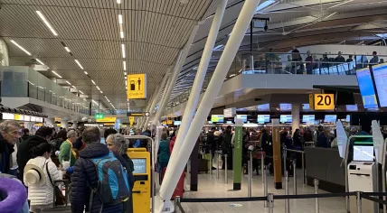 People lined up from security checkpoints to the airline check-in counters at Schiphol Airport. Many had to wait outside, as well. 17 October 2022
