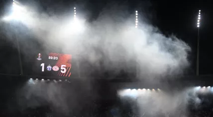 FC Zurich's supporters wave flags under the score board half hidden by smoke during the UEFA Europa League football 1st round day 3 group A match between FC Zurich and PSV Eindhoven at Letzigrund stadium in Zurich on October 6, 2022. 