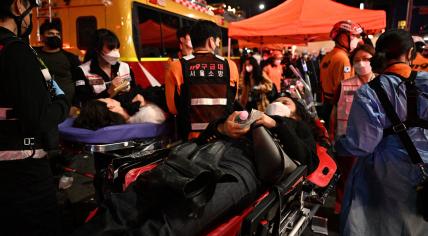 People lie on stretchers to receive medical attention in the popular nightlife district of Itaewon in Seoul on Oct. 30, 2022.