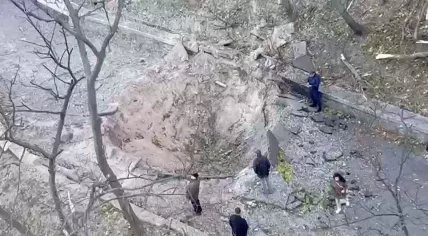 Bystanders gather around a crater where a missile strike landed near the Bridge over Saint Volodymyr Descent in Kyiv. 10 October 2022