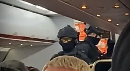 Two police tactical officers board an EasyJet flight at London Stansted Airport to investigate a bomb threat. 19 October 2022