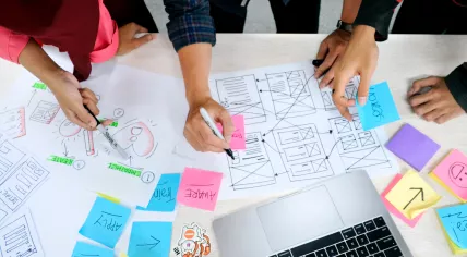 Colleagues try to sketch out the design of a website