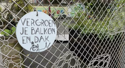 A sign promoting greener balconies and rooftops at a public garden space in Amsterdam Oost, 4 November 2022