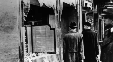 People in Berlin examine a storefront destroyed during Kristallnacht. 10 November 1938
