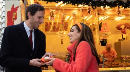 Foreign Minister Wopke Hoekstra accepts oliebollen from U.S. ambassador Shefali Razdan Duggal, whose handing them out around Den Haag Central Station after Oranje beat the U.S. in the Qatar World Cup, 7 December 2022