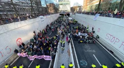Extinction Rebellion activists block the Utrechtsebaan of the A12 highway in The Hague as hundreds of people cheer them on from the sidelines, 28 January 2023