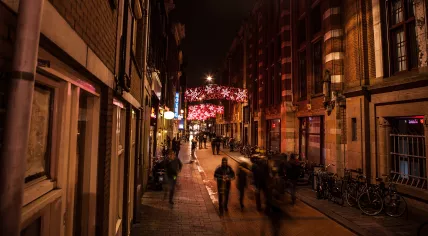 A group of people walking on the Warmoesstraat in Amsterdam at night. 17 February 2016